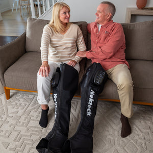 An Elderly Couple Using Air Compression Full Leg Boot On Sofa