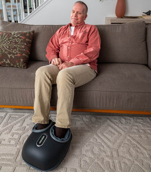 Old_man_use_foot_massager_on_sofa